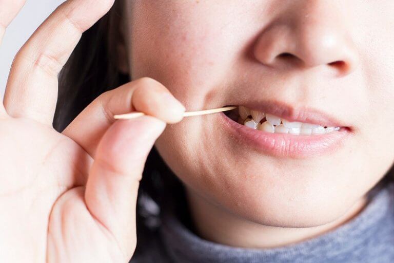 Stock image showing a girl using tooth pick