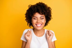 Gummy Smile Treatment Hollywood, CA- happy woman with yellow background